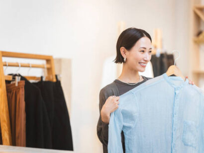 A Japanese woman is choosing clothes at a store.